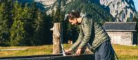 Hiker refilling his water bottle on Rudl Eller hiking path | Lukas Nagler