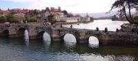 Pilgrims crossing a bridge along the Portuguese Way