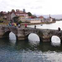 Pilgrims crossing a bridge along the Portuguese Way