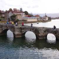 Pilgrims crossing a bridge along the Portuguese Way