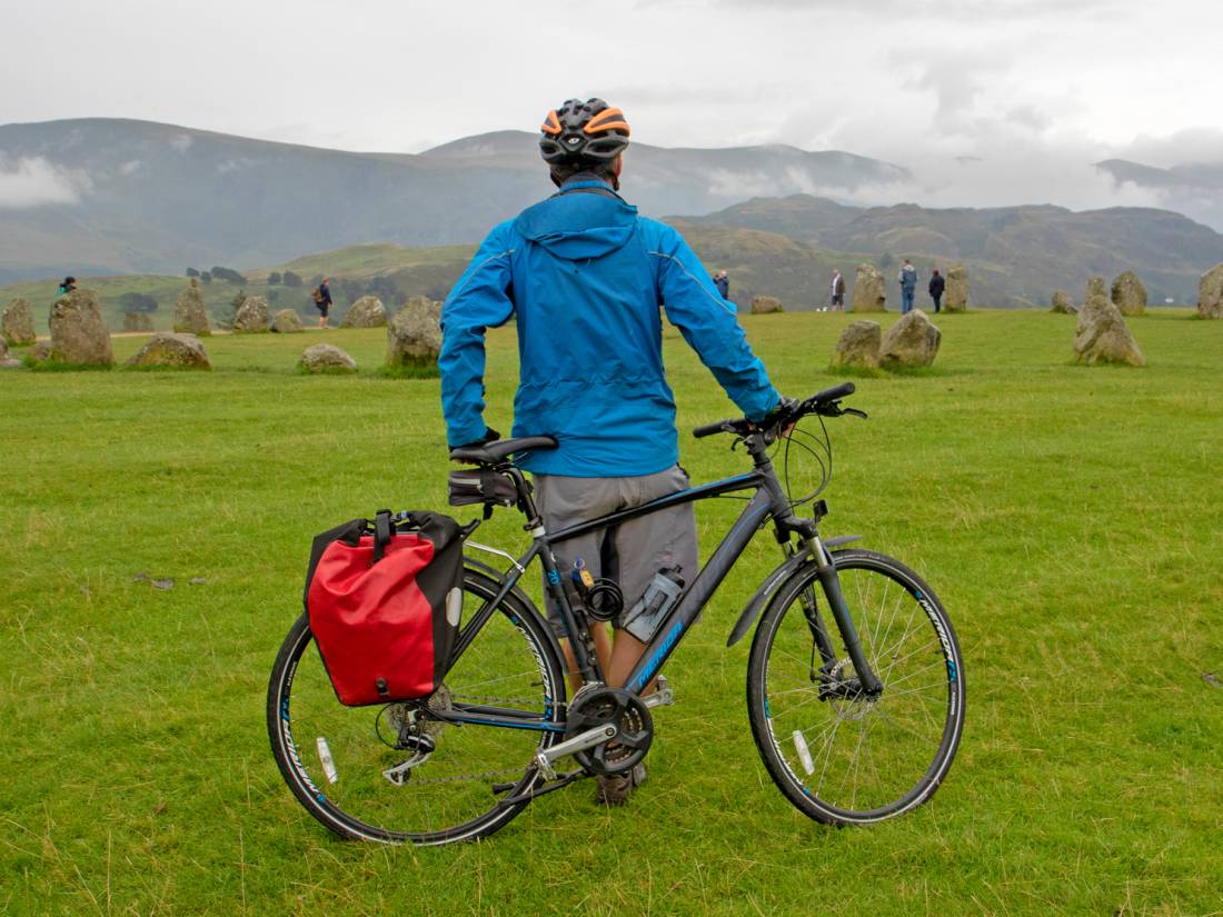 Cyclist taking in the atmospheric Castlerigg Stone Circle