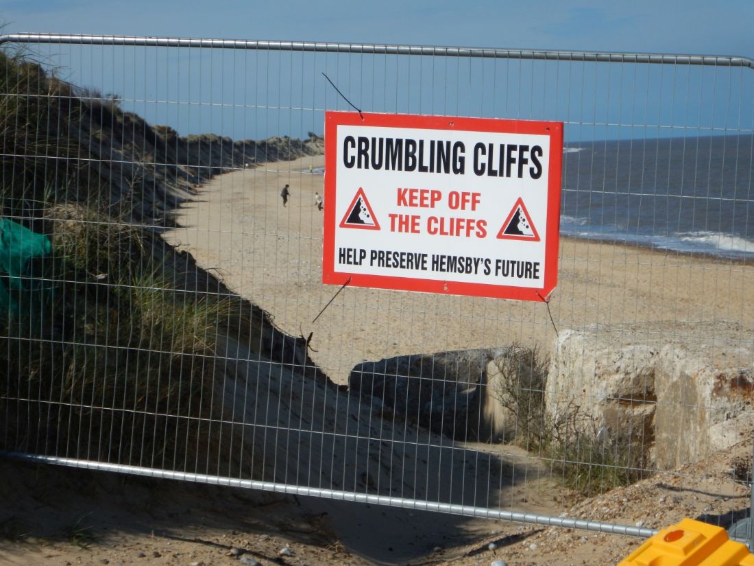Norfolk Coast Path walking route closed by a crumbling cliffs warning sign above the beach |  Peter Wells