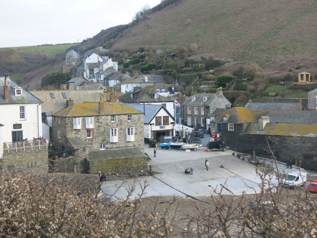 South West Coast Path walkers look down over a stone coastal village |  Peter Wells