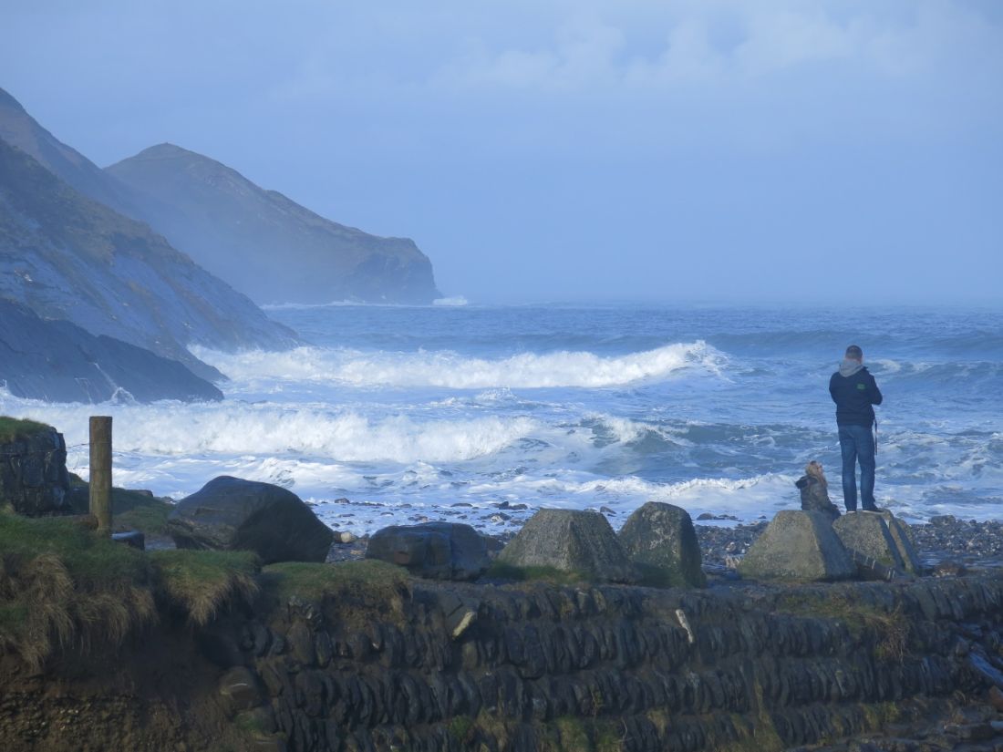 South West Coast Path walker watching waves below rugged cliffs, England |  Peter Wells