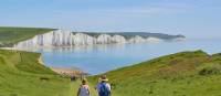 A couple walking towards the Seven Sisters on the South Downs Way | Marc Najera