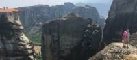 Hikers above a precipitous ridge overlooking Varlaam Monastery in Meteora | Kate Baker