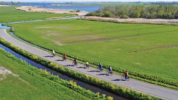 Cyclists enjoying the flat polder landscape of northern Holland