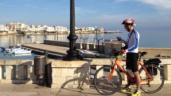 Cyclist on waterfront in Otranto | Kate Baker