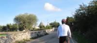 Cyclists approaching trulli houses near Alberobello, Puglia | Kate Baker