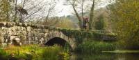 A pilgrim crosses an ancient bridge over the Neiva River in Portugal | Miguel Da Santa