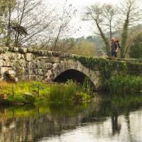 A pilgrim crosses an ancient bridge over the Neiva River in Portugal | Miguel Da Santa