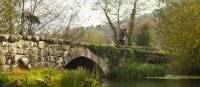 A pilgrim crosses an ancient bridge over the Neiva River in Portugal | Miguel Da Santa