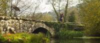 A pilgrim crosses an ancient bridge over the Neiva River in Portugal | Miguel Da Santa