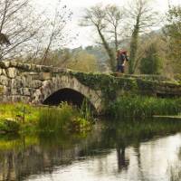 A pilgrim crosses an ancient bridge over the Neiva River in Portugal | Miguel Da Santa