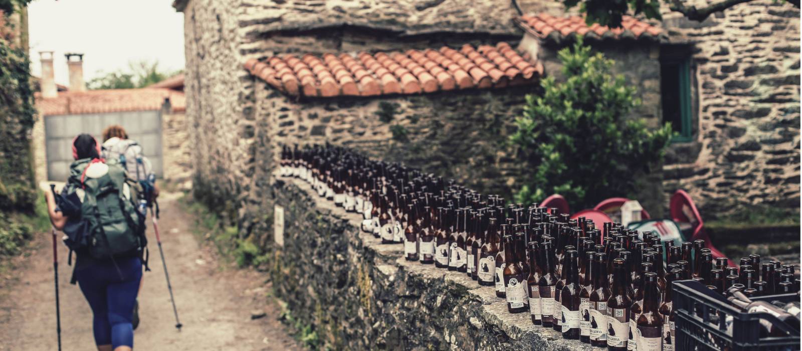 Pilgrims hiking through small village on the Camino | @timcharody
