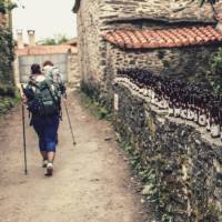 Pilgrims hiking through small village on the Camino | @timcharody