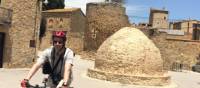 Man cycling through the village of Palau Sator in Catalonia on a self guided cycle holiday | Kate Baker