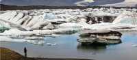 Man viewing icebergs carved from Breidamerkurjokull in Jokulsarlon glacial lagoon. | Richard I'Anson