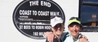 Happy hikers at the end of the Coast to Coast Trail in Robin Hood's Bay | John Millen
