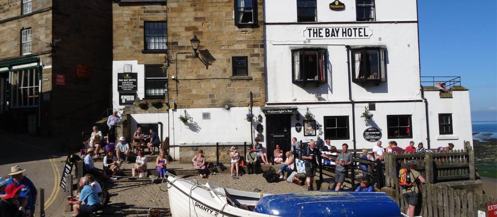 Walkers celebrating the end of the Coast to Coast in Robin Hood's Bay | John Millen
