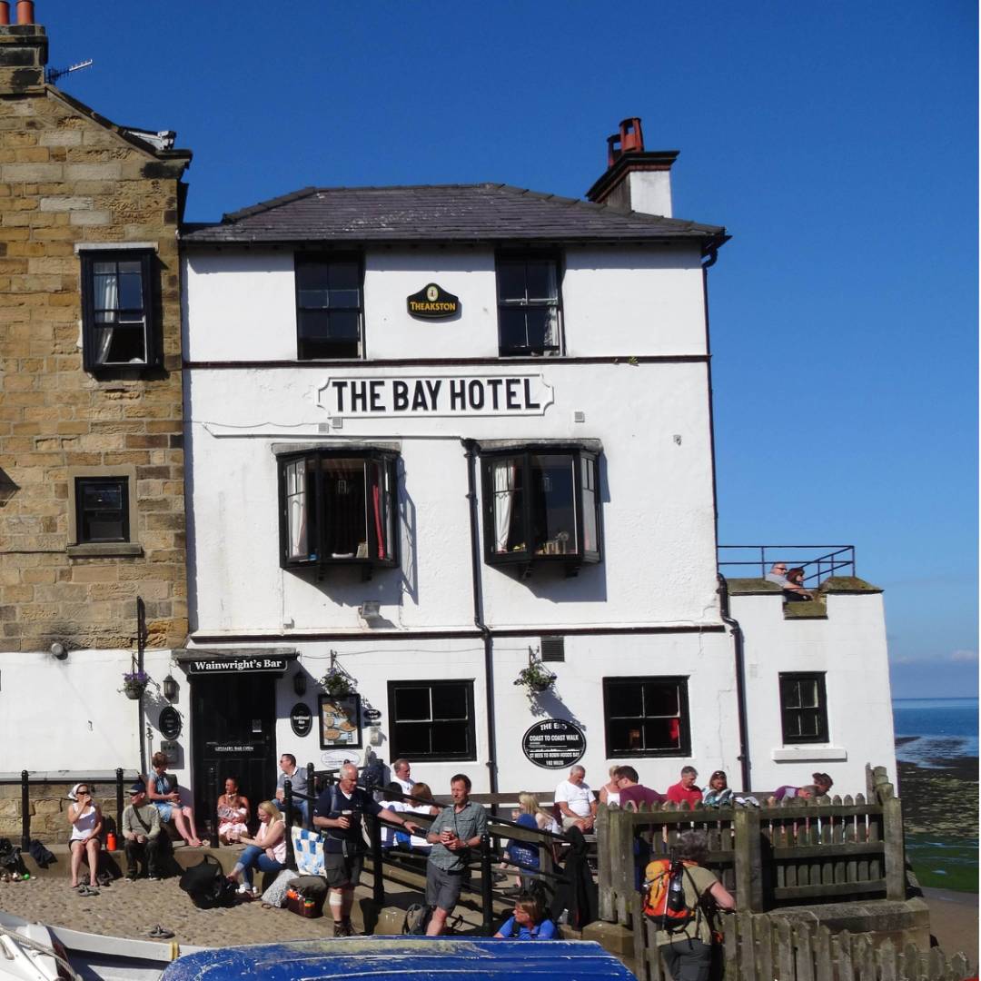 Walkers celebrating the end of the Coast to Coast in Robin Hood's Bay | John Millen