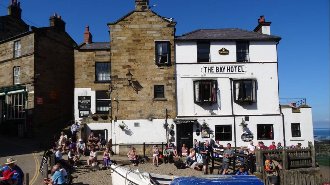 Walkers celebrating the end of the Coast to Coast in Robin Hood's Bay |  <i>John Millen</i>