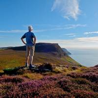 A walker enjoys a hilltop view on the Isle of Man