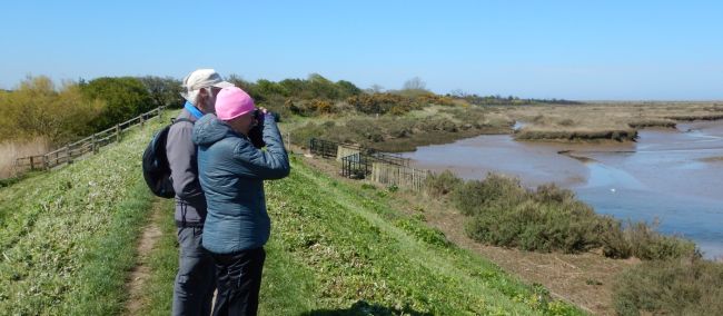 Norfolk Coast Path walkers pause to view a tidal estuary with binoculars | Peter Wells