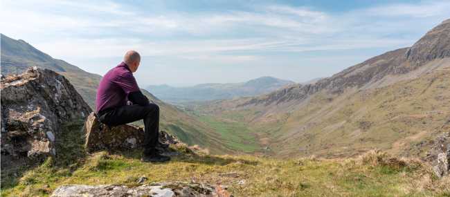 A walker admiring the view of Cwm Croesor from Cnicht, Gwynedd, Wales | Rob Thorley